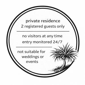 a sign with a palm tree in a circle at Quiet couples-only beachfront retreat overlooking Coolum Bays in Coolum Beach