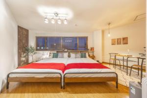 a bedroom with a bed with a red blanket on it at Cozy Stay Kamui in Asahikawa