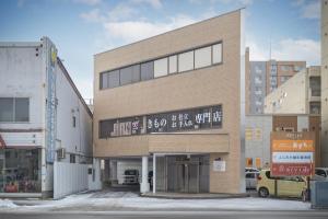 a building with a sign on the front of it at Cozy Stay Kamui in Asahikawa