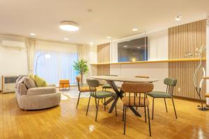 a living room with a table and chairs at Cozy Stay Kamui in Asahikawa