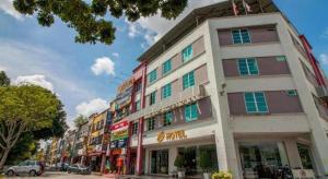 een hoog wit gebouw met ramen aan een straat bij e Hotel in Melaka