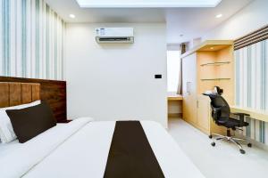 een slaapkamer met een bed, een bureau en een stoel bij Townhouse Oak Ram Lala Mandir Kanpur Formerly Hotel Sun Rise in Kaliānpur