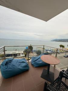 a balcony with two bean bags and a table and the ocean at Shengjini holiday home beautiful in Lezhë