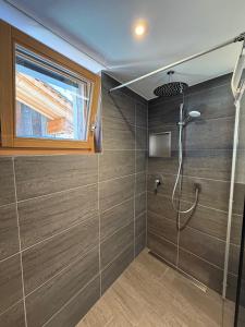 bagno con doccia e finestra di Larix a Ulrichen