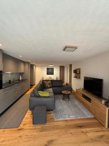 un soggiorno con un divano e una TV di Larix a Ulrichen