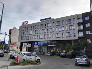 a large building with cars parked in a parking lot at Sweet Heart Home in Szczecin