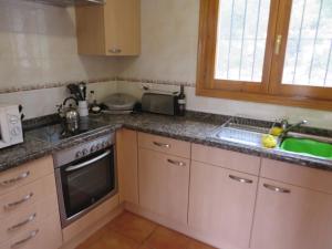 a kitchen with a sink and a stove top oven at *Casa Anna L'Atzubia in Adsubia