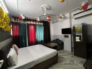 a bedroom with a bed and a couch and balloons at Hotel the diamond Ring in Chandīgarh +6 photos