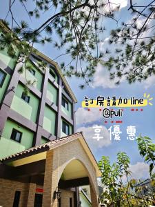 een bord voor een hotel met een gebouw bij Green Castle in Ch'ieh-tung-chiao