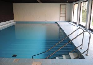 an empty swimming pool with a staircase in a building at Residenza Golf Parco by Fewotessin in Ascona