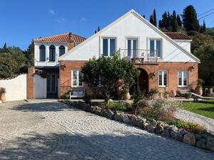 a large house with a driveway in front of it at Buddha Villa in Arillas
