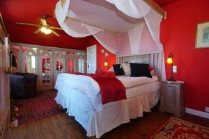 a bedroom with a large bed with red walls at Buddha Villa in Arillas +18 photos