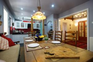 a kitchen and dining room with a large wooden table with platesurrencyangering at Buddha Villa in Arillas