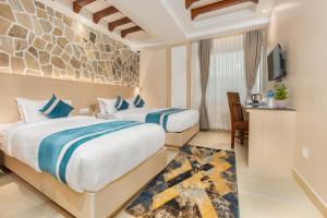 a hotel room with two beds and a television at Tulsi Kathmandu Hotel in Kathmandu