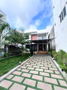 een huis met een stenen loopbrug voor een gebouw bij Tamizh Agam in Ramanathapuram