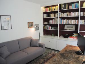 a living room with a couch and a book shelf at La Civetta by Fewotessin in Brissago