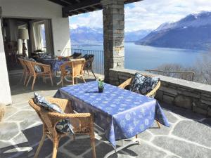 a table and chairs on a patio with a view of a lake at La Civetta by Fewotessin in Brissago