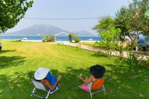 アギオカンポスにあるApartments Skardoutsouの海辺の芝生の上に座る子供2人