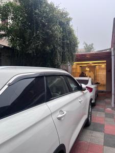 a white car parked in front of a house at Gulberg Residency Hotel in Lahore