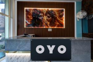 ein Schild für einen Ovo-Laden mit einem Poster von zwei Frauen in der Unterkunft SPOT ON Hotel The Baithak & Restaurant in Etāwah