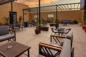 a patio with tables and chairs and tables and chairs at فندق براي Brai Hotel in Ad Dawādimī