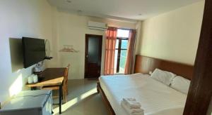 a bedroom with a bed and a desk and a television at JITRA RESORT in Sukhothai
