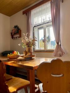 einen Tisch mit einer Blumenvase neben einem Fenster in der Unterkunft Chata Rychnovanka in Zdobnice + 12 Fotos