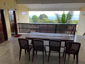 a wooden table and chairs in a room with a balcony at Para Hostel Kohrong in Kaôh Rŭng (3)