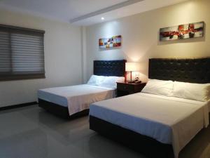 een hotelkamer met twee bedden en een raam bij Sabine's Place in Cangbaliguia +144 foto's