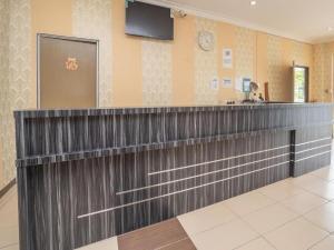 eine Bar in einem Wartezimmer mit einem TV an der Wand in der Unterkunft Sz Hotel in Kampong Tebing Rabak