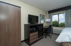 a hotel room with a bed and a desk with a television at Best Western Travelers Rest/Greenville in Travelers Rest