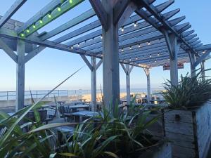 een patio met tafels, stoelen en verlichting bij Ollys House in Prestatyn