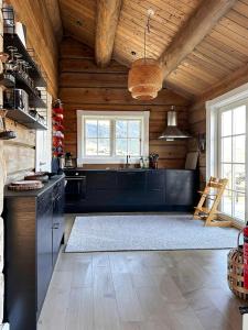 a kitchen with wooden walls and a ceiling at Spectacular Cabin With View In Jotunheimen in Eidsbugarden