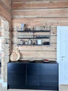 a black cabinet in a kitchen with wooden walls at Spectacular Cabin With View In Jotunheimen in Eidsbugarden