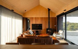a living room with a couch and a fireplace at Native Dog Cabin in Bremer Bay