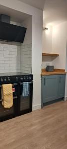 a kitchen with a black stove and a counter at Ground Floor Apartment, Garden and free parking - 10 The Rise in Kirkstall