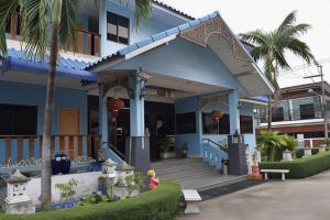 ein blaues Haus mit einer Palme davor in der Unterkunft Kiatwimon Hotel in Sathani Phitsanulok