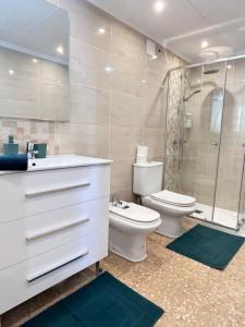 a bathroom with a toilet sink and a shower at On the Beach Oliva in Oliva +16 photos