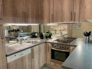 a kitchen with wooden cabinets and stainless steel appliances at Portofino by Fewotessin in Brissago