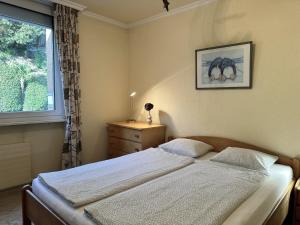 a bedroom with a bed and a window at Portofino by Fewotessin in Brissago +25 photos