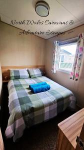 a bedroom with two beds and a sign on the wall at Park Dean Resorts Premium plot with Mountain view & Decking in Abergele