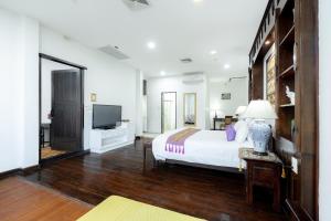 a large bedroom with a bed and a television at Cheva Gallery Boutique Hotel in Chiang Mai