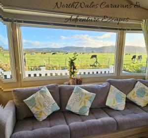 a couch in a living room with a view of a field at Park Dean Resorts Premium plot with Mountain view & Decking in Abergele