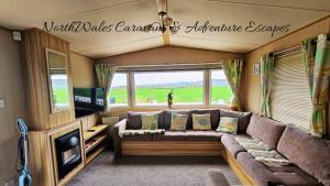 a living room with a couch and a tv at Park Dean Resorts Premium plot with Mountain view & Decking in Abergele