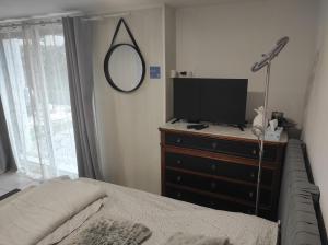 una camera da letto con un letto e una televisione su una cassettiera di Chambre entrée indépendante a Lodève