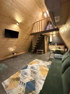un soggiorno con un divano e una scala di A Frame Loft Calimanesti a Călimăneşti