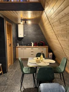 una cucina con un tavolo e sedie in una stanza di A Frame Loft Calimanesti a Călimăneşti