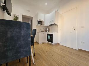 a kitchen with white cabinets and a table and chairs at Olimpo Caserta in Caserta