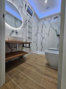 a bathroom with a sink and a tub and a mirror at Olimpo Caserta in Caserta +58 photos