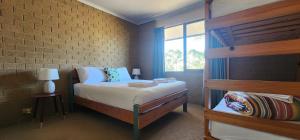 a bedroom with a bed and a brick wall at Pomonal Cottages Grampians in Halls Gap